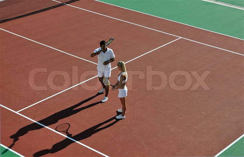 Happy young couple play tennis game outdoor man and woman, stock photo