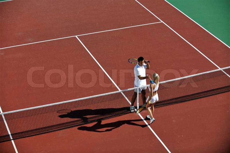 Happy young couple play tennis game outdoor man and woman, stock photo