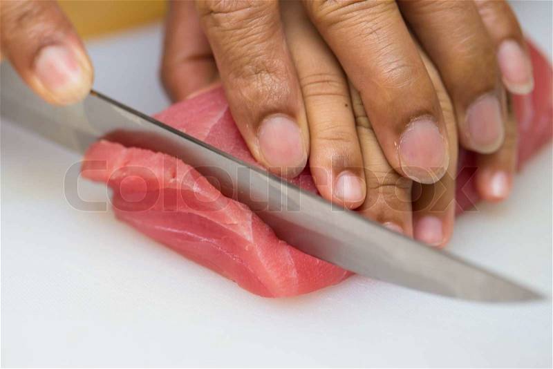 Hand was sliced ​​fish to make sushi, stock photo