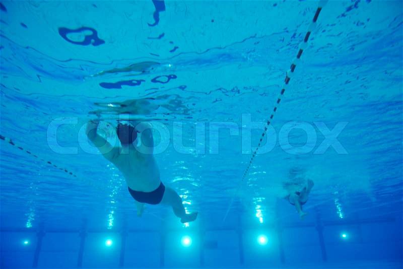 Sport swimming pool underwater with blue color and swimmers, stock photo