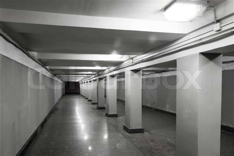 Underground passage interior with lights and concrete columns , stock photo