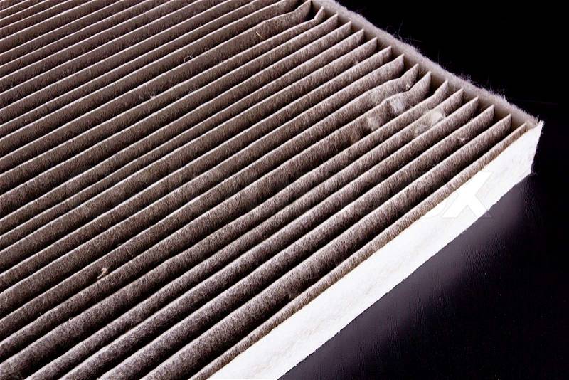A dirty air filter car on a black table, stock photo