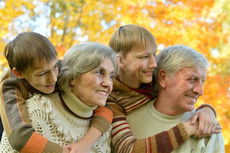 Portrait of a cute grandparents with grandchildren in fall park, stock photo