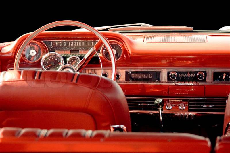 Interior of classic or vintage car with red leather interior and dashboard, stock photo