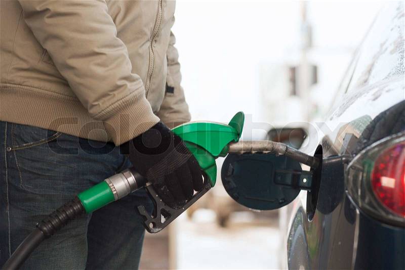 Vehicle and fuel concept - close up of male refilling car fuel tank, stock photo