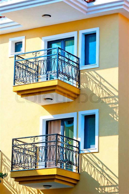 Two small balconies on the yellow house, stock photo