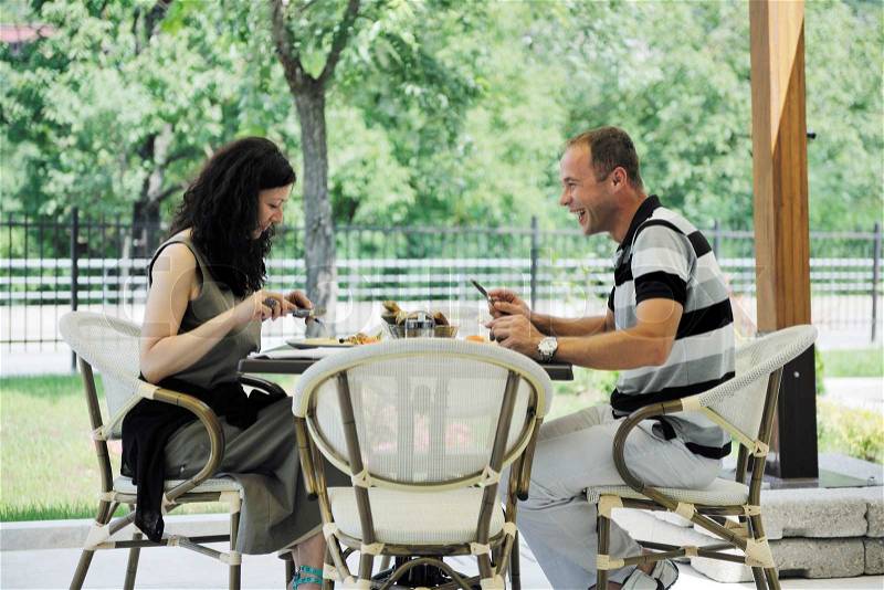 Happy young couple eat fresh food at beautiful restaurant restaurant outdoor, stock photo