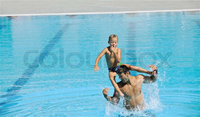 Happy father and son have fun at swimming pool, stock photo