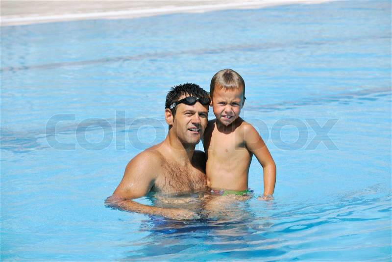 Happy father and son have fun at swimming pool, stock photo
