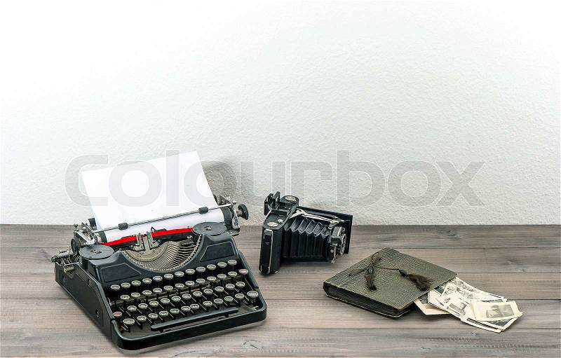 Retro typewriter and vintage photo camera on wooden table. antique objects. collectibles, stock photo