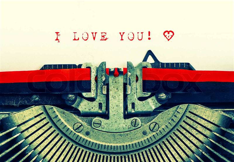 Old typewriter with sample text I LOVE YOU! Red words with heart on white paper. Retro style toned picture, stock photo