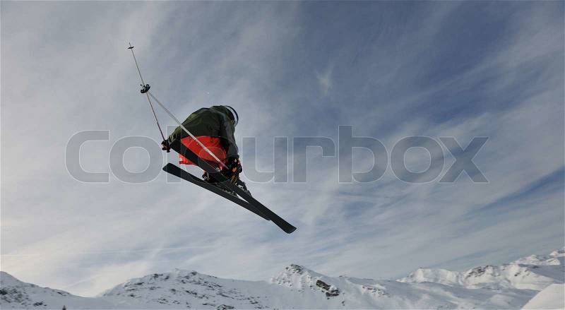 Extreme freestyle ski jump with young man at mountain in snow park at winter season, stock photo