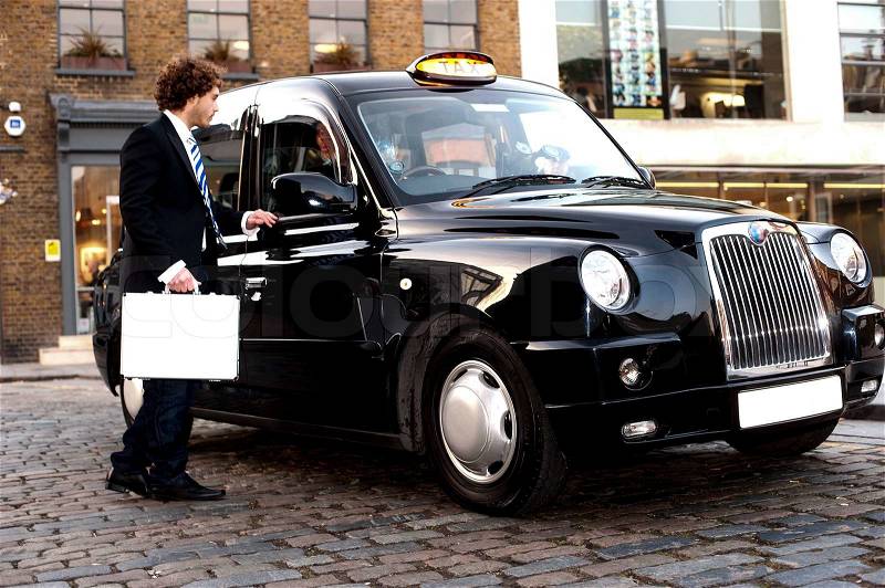 Taxi cab driver communicating with male passenger, stock photo