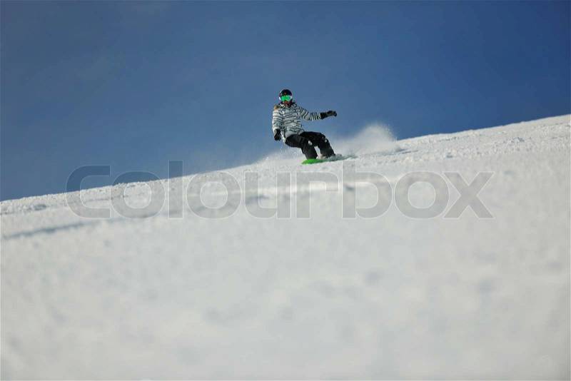 Snowboard woman racing downhill slope and freeride on powder snow at winter season and sunny day, stock photo