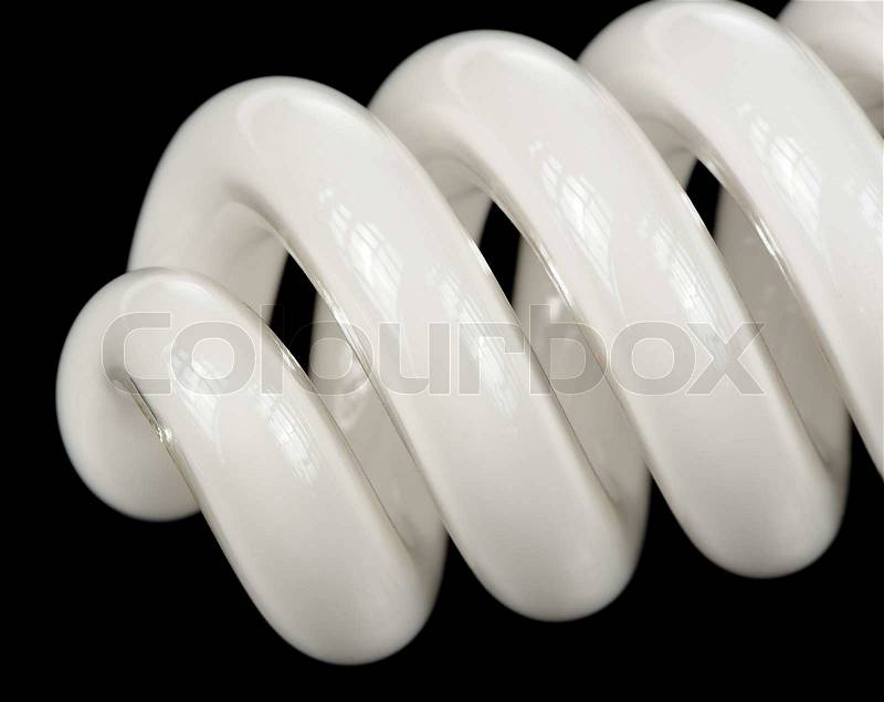 A close-up of an energy saving (economy) fluorescent light bulb on a black background with copy space, stock photo
