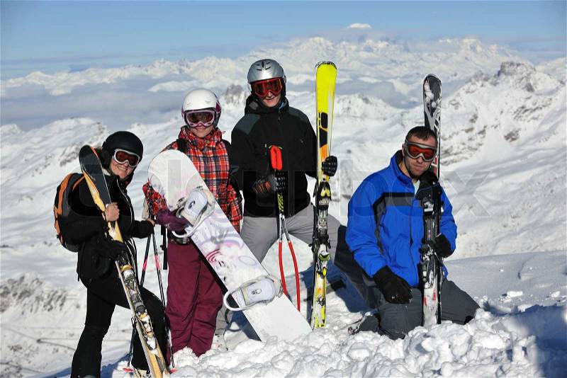 Happy people group have fun on snow at winter season on mountain with blue sky and fresh air, stock photo