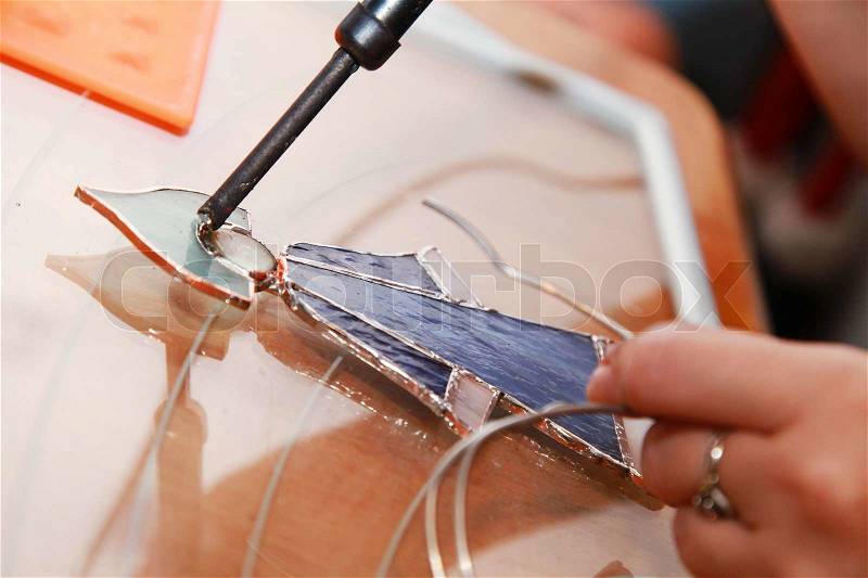 Stained glass maker at work on Russian winter girl souvenir , stock photo