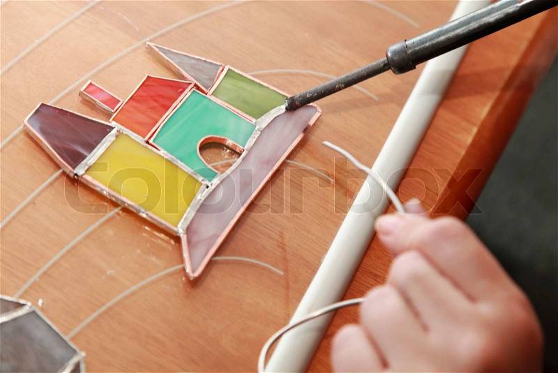 Stained glass maker at work on colorful castle, stock photo