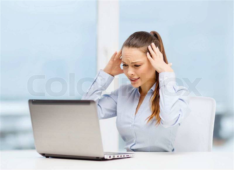 Business, office and technology concept - stressed businesswoman with laptop at work, stock photo