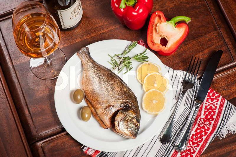 Grilled fish with rosemary, lemon and white wine, stock photo
