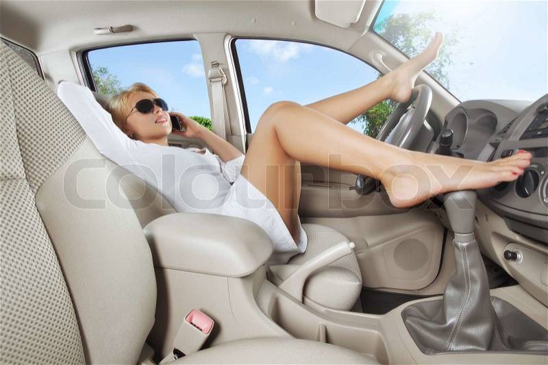 Portrait of young beautiful woman sitting in the car, stock photo