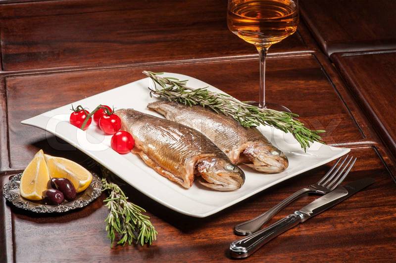 Grilled fish with rosemary, tomatoes and white wine, stock photo