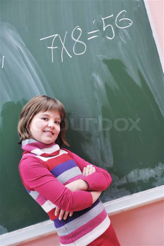 Happy school girl on math classes finding solution and solving problems, stock photo