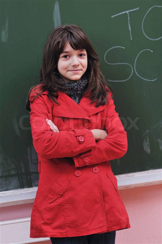 Happy school girl on math classes finding solution and solving problems, stock photo