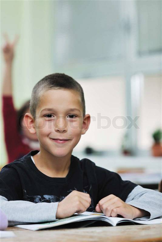 Happy young boy at first grade math classes solving problems and finding solutions, stock photo