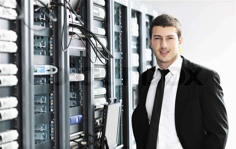 Young it engeneer business man with thin modern aluminium laptop in network server room, stock photo