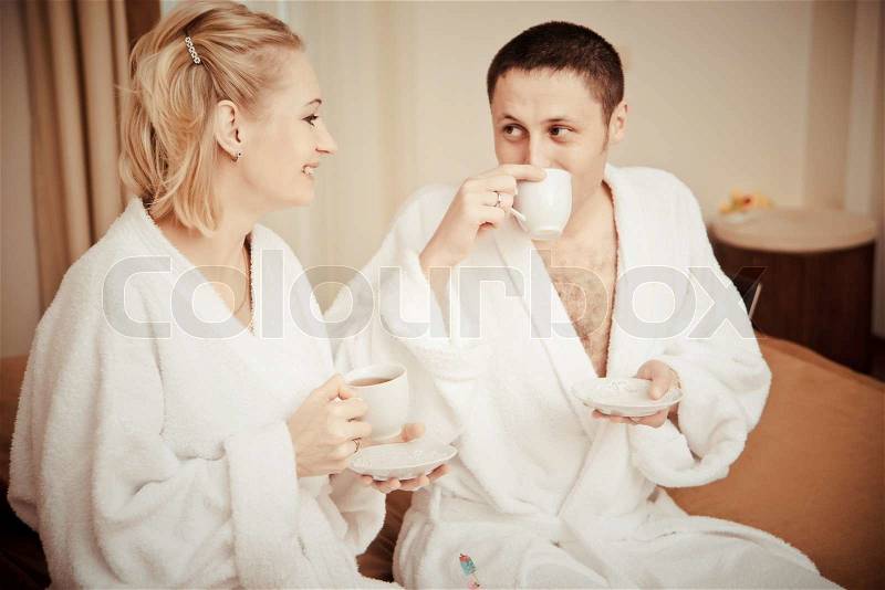 Man and woman drinking coffee in the morning in bed. Young lovers lay in bed. man and woman eat cake in bed, stock photo