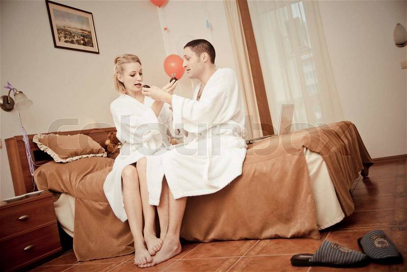 Man and woman drinking coffee in the morning in bed. Young lovers lay in bed. man and woman eat cake in bed, stock photo
