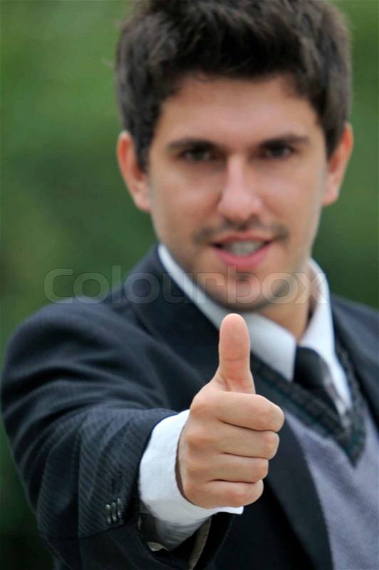Young caucasian business man in a suite, pointing at camera to you, stock photo