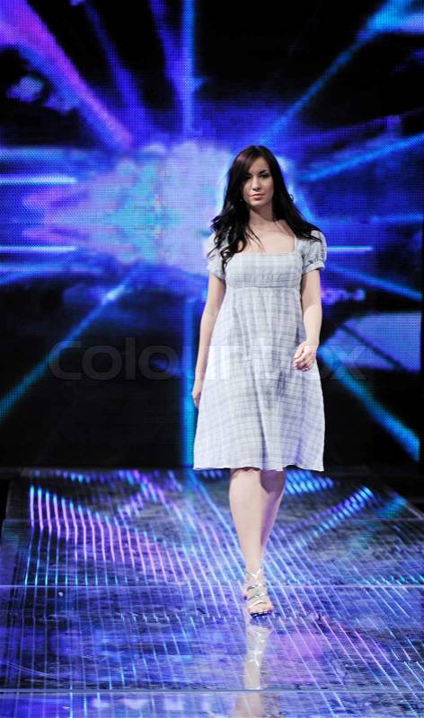 Beautiful young fashion model woman walking on fashion show event , stock photo