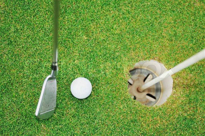 Golf ball on sports golf course and hole, stock photo