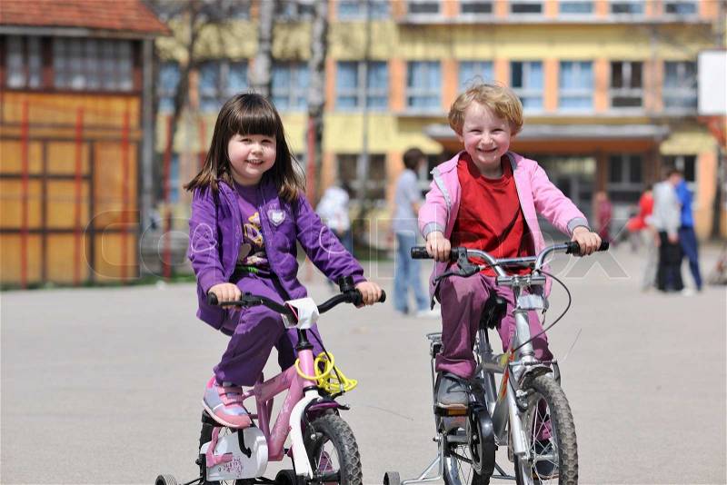 Happy childrens group learning to drive bicycle outdoor at beautiful sunny spring day, stock photo