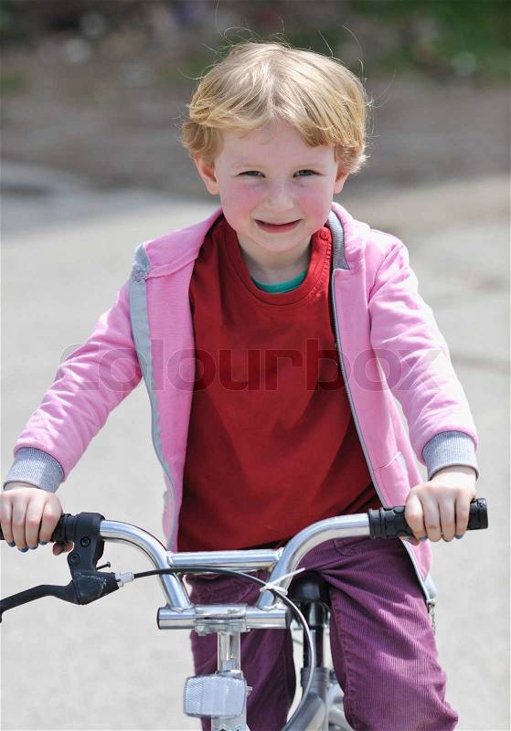 Cute little girl learn to drive bicyle at sunny day , stock photo