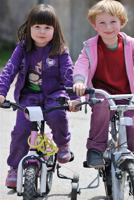Happy childrens group learning to drive bicycle outdoor at beautiful sunny spring day, stock photo