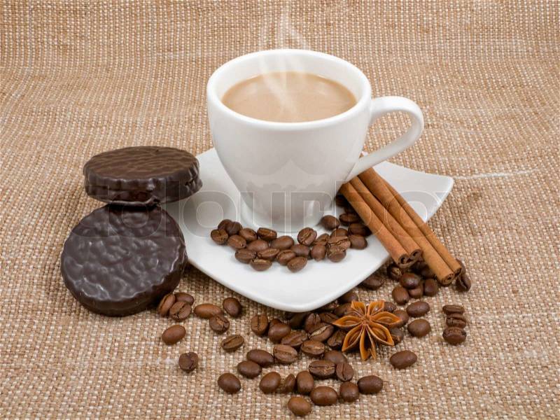 Coffee and milk, cinnamon, anise and biscuits on a background sacking, stock photo