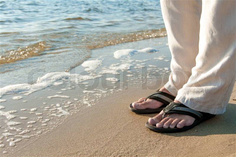 man\'s legs in an open shine on the sea shore, stock photo