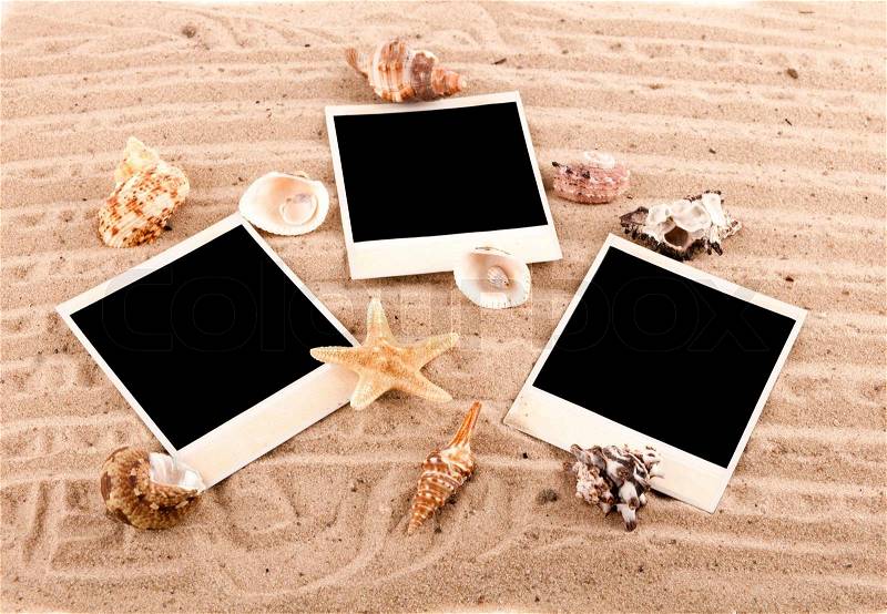 three cards lie on the sand with sand-dunes and shells, stock photo