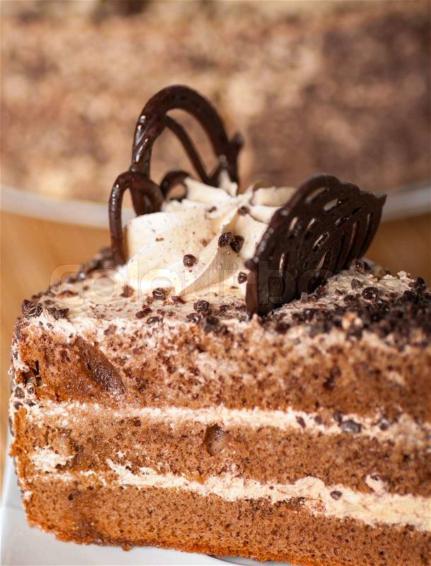 piece of cake on a plate with a spoon against the background of a cake, stock photo