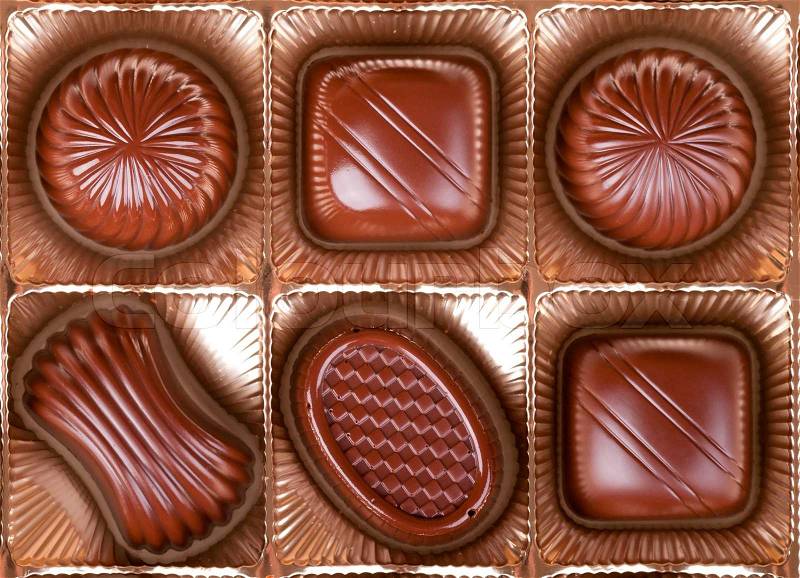 Chocolate sweets lie in the cells of the boxes in a number of, stock photo