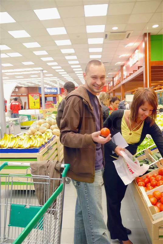 Happy couple buying fruits in hypermarket, stock photo