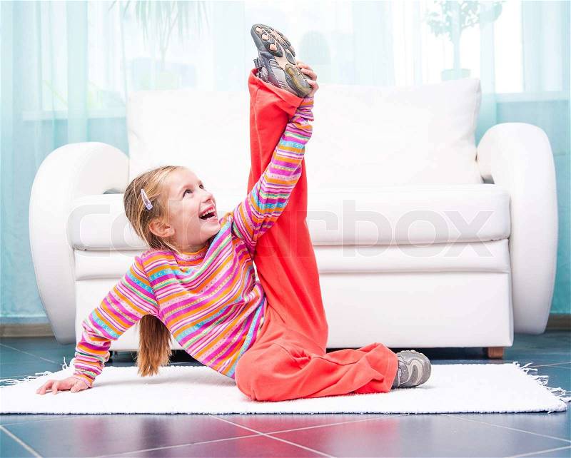 Pretty little girl playing sports at home, stock photo