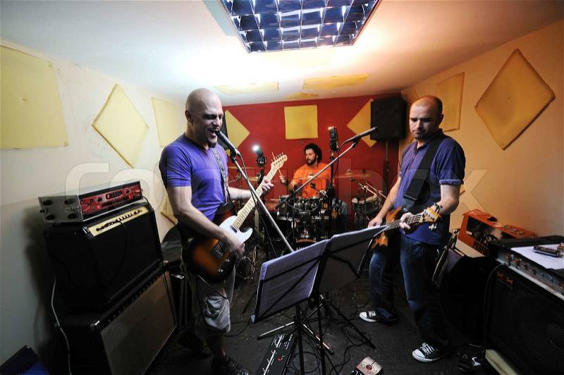 Young music player and band friends have training in home garage, stock photo