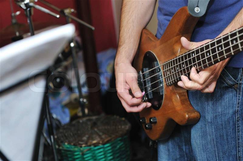 Young music player and band friends have training in home garage, stock photo