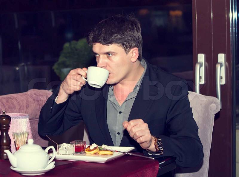 Young man having dinner in a restaurant, stock photo