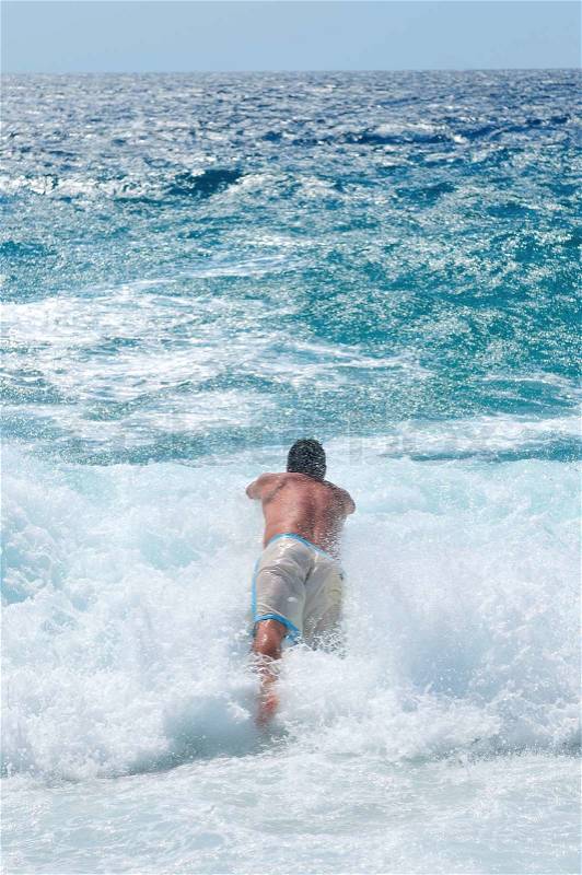 Happy man jump in sea with big waves, stock photo