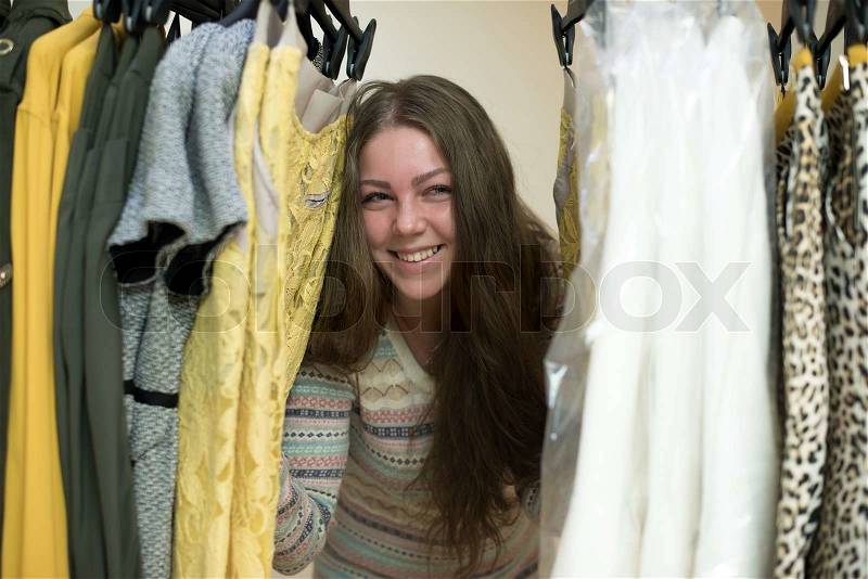 Woman choosing clothes from her robe, stock photo